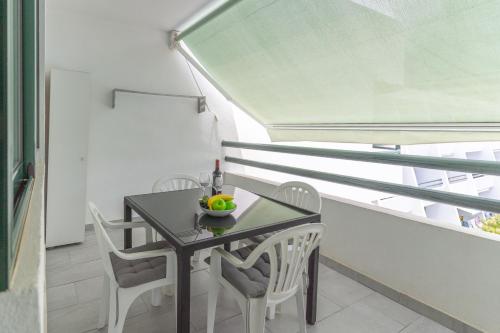 a small table and chairs in a room with a window at GO2TENERIFE Apart'Teno Amazing pool view & near the beach in Playa de las Americas