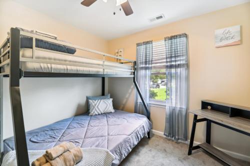 a bedroom with a bunk bed and a desk at Quaint Jacksonville Getaway Near Camp Lejeune! in Jacksonville