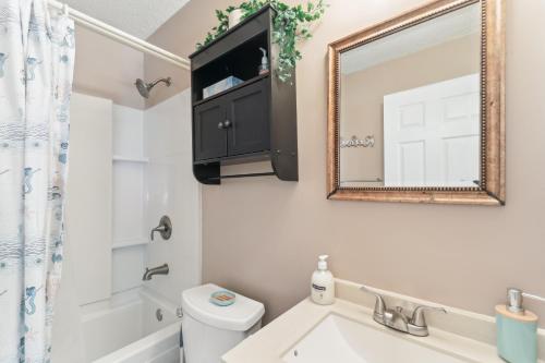 bagno con lavandino e specchio di Quaint Jacksonville Getaway Near Camp Lejeune! a Jacksonville