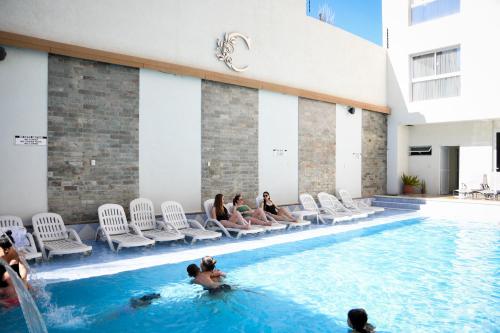 a group of people sitting in a swimming pool at Hotel Cálido Termal in Termas de Río Hondo