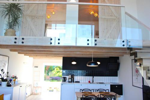 a kitchen with white cabinets and a table with chairs at Sea2 in Nowęcin