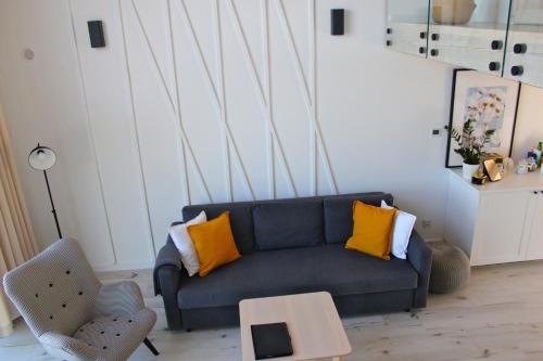 a living room with a blue couch and yellow pillows at Sea2 in Nowęcin
