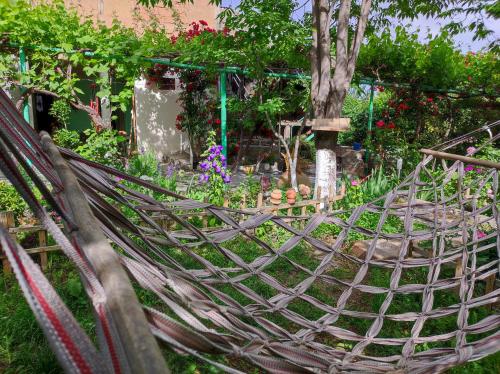 a hammock in a garden with flowers and plants at Our Village in Ashtarak