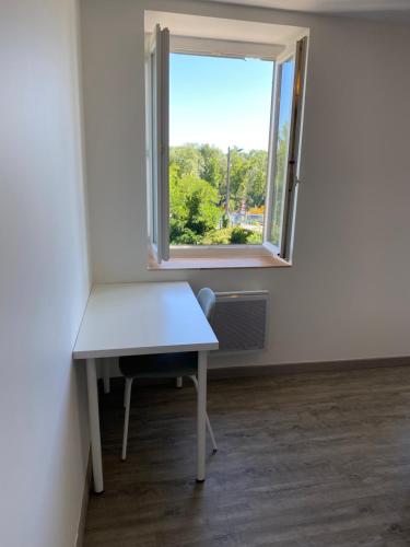 um quarto vazio com uma secretária e uma janela em Maison des Balmes proche Lyon em Miribel