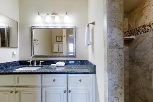 a bathroom with a sink and a mirror and a shower at 207 Sailmaker in Fernandina Beach
