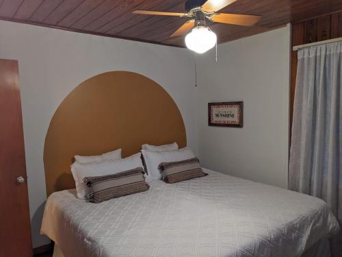 um quarto com uma cama e uma ventoinha de tecto em Mid Century Style Cottage Near Historic Downtown em Eustis