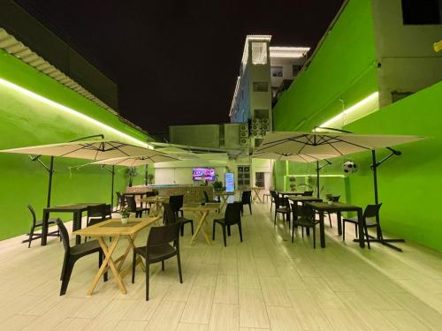 ein Restaurant mit Tischen und Stühlen und grünen Wänden in der Unterkunft Libertad 109 Hotel in La Libertad