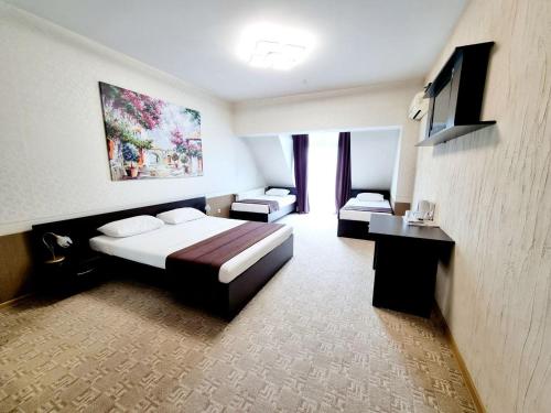 a hotel room with a bed and a tv at TipTop Hotel CITY CENTER in Chişinău