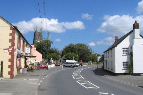una calle vacía en un pequeño pueblo con una iglesia en Wood View - Penstowe Park, en Kilkhampton