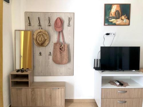 a living room with a tv and a wooden cabinet at Bar Aperol Apartment in Bar