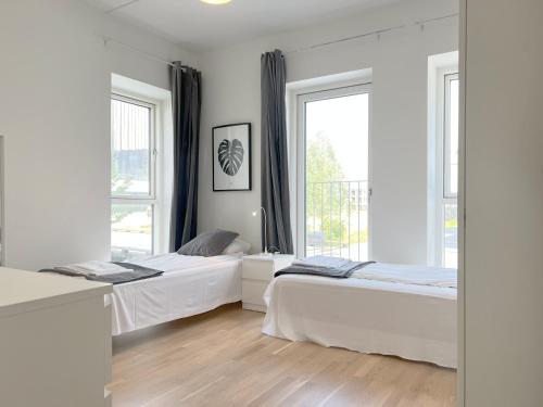 duas camas num quarto com duas janelas em Spacious 3 Bedroom Apartment With Balcony At Richard Mortensens Vej em Copenhaga