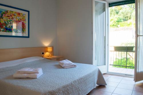 a bedroom with a bed with two towels on it at Nice apartment lake view & free parking in Pastrengo
