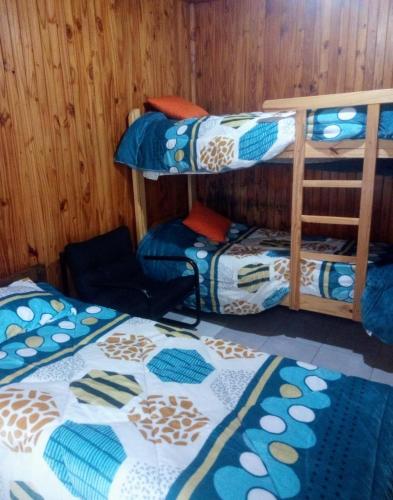 a room with three bunk beds in a room at Cabaña Carmela in Garupá