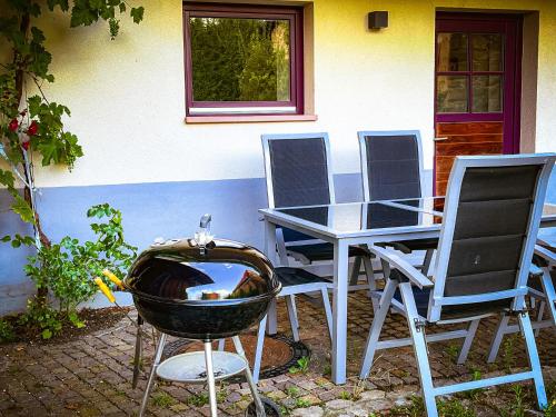 a grill and chairs and a table and a table and chairs at Storchenhof Teningen in Teningen