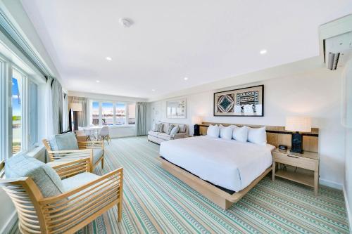 um quarto de hotel com uma cama e cadeiras em Mahalo Cape May em Cape May