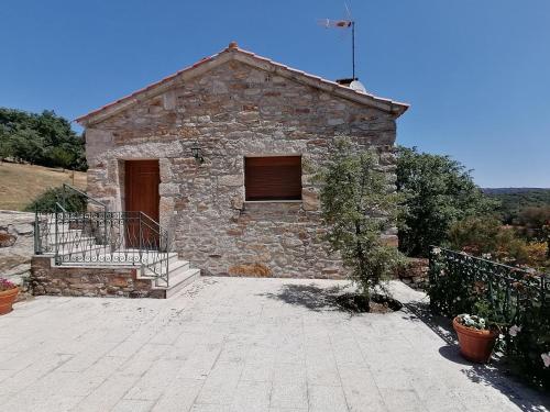 a small stone building with a staircase in front of it at LÍRIOS DA GRANJA - CASA DE CAMPO in Granja
