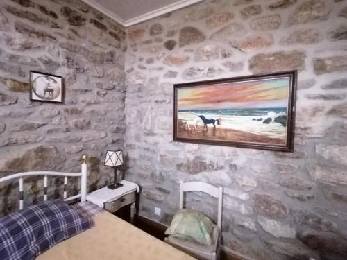 1 dormitorio con 1 cama y una pintura en la pared en LÍRIOS DA GRANJA - CASA DE CAMPO, en Granja