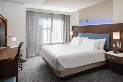 a hotel room with a large bed and a desk at EVEN Hotels - Shenandoah - The Woodlands by IHG in The Woodlands
