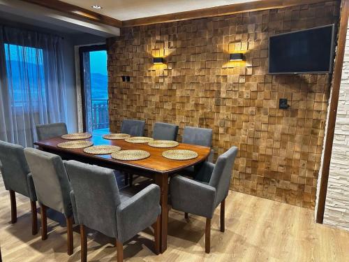 a dining room with a table and chairs and a television at Villa Monte in Velingrad