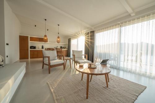 ein Wohnzimmer mit einem Tisch und einigen Stühlen in der Unterkunft Gizz Suites in Fethiye
