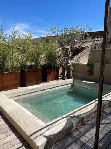 une piscine au milieu d'une cour dans l'établissement Villa de charme, à Châteauneuf-de-Gadagne