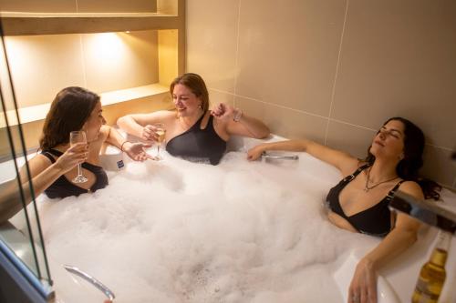drei Frauen in einer Badewanne voller Schaum in der Unterkunft Hotel Cálido Termal in Termas de Río Hondo