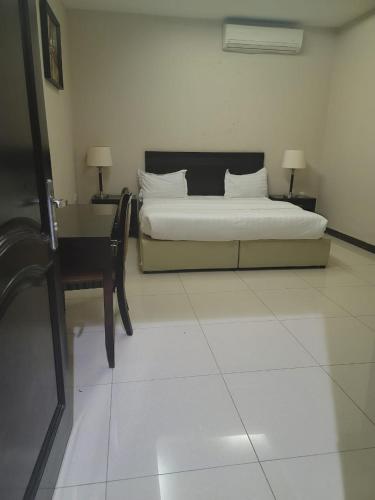 1 dormitorio con 1 cama y escritorio con 2 lámparas en Quiet Rooms 8, en Riad