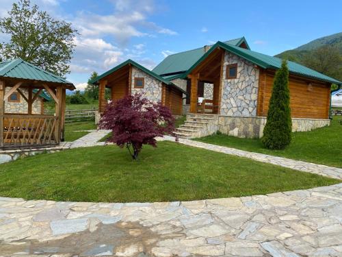 a log cabin with a stone path in front of a house at Ethno House Bektesevic in Gusinje