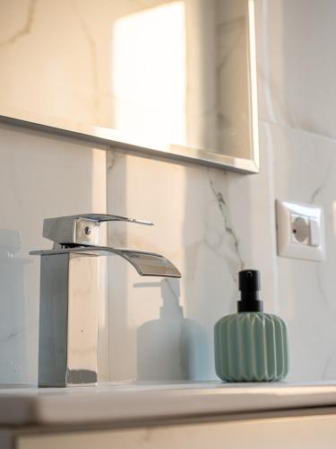 a bathroom sink with a faucet and a soap dispenser at Maestrale Apartment in Cagliari