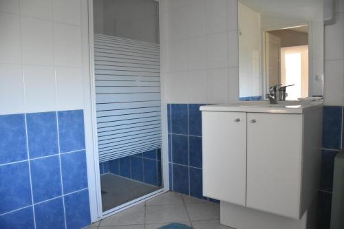 a bathroom with a sink and a shower with blue tiles at Ancienne ferme tranquille en Haute Ardèche in Étables