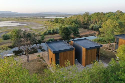 una vista aérea de dos casas de madera con un río en Salinas Nest - Ulcinj Stoj Ada Bojana en Ulcinj