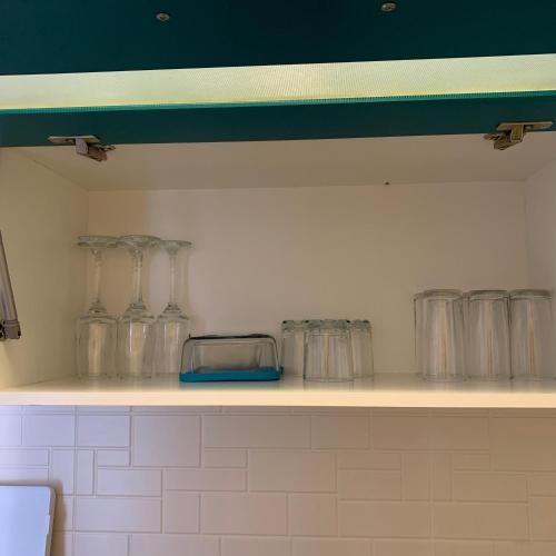 a row of glass jars sitting on a shelf at Apartment Mari in Kutaisi