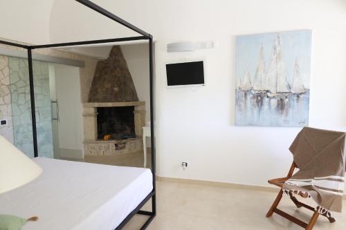 ヴィエステにあるTenuta Valle Della Corteのベッドルーム(暖炉、ベッド1台、椅子付)