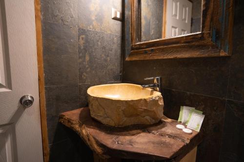 a bathroom with a stone sink and a mirror at Hotel Don Raul in San Pedro de Atacama