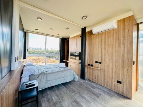 a bedroom with a bed and a large window at Cubos de Chacras AZUL in Mendoza