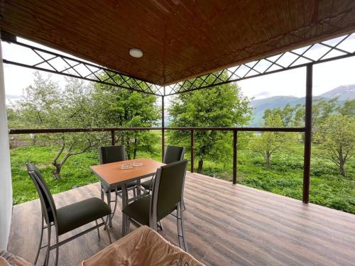a dining room with a table and chairs on a deck at Riverside Rancho guest house in Lermontovo
