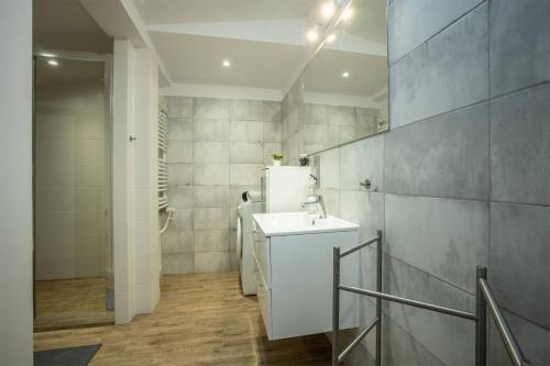 een badkamer met een witte wastafel en een witte koelkast bij Centric Rooftop 4 bedroom apartment in Łódź