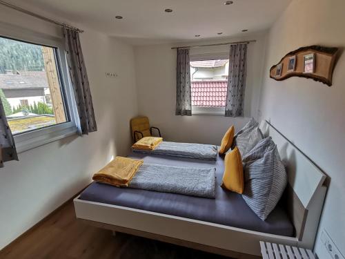 two beds in a room with two windows at Ferienwohnung Pilgram-Huber in Afritz