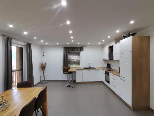 a kitchen with white cabinets and a wooden table at Ferienwohnung Pilgram-Huber in Afritz