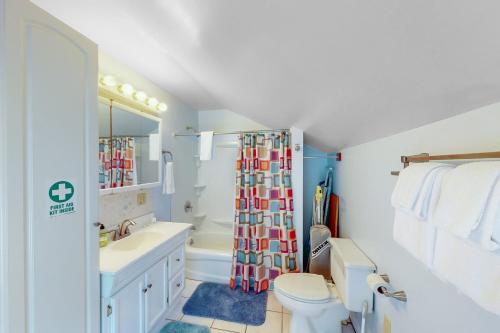 a bathroom with a toilet sink and a shower curtain at Harbor Haven in Bass Harbor