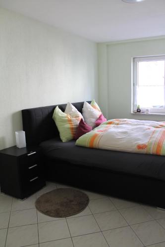 Sofá negro con almohadas en un dormitorio en Gemütliches Apartment, nahe Wetzlar en Wetzlar