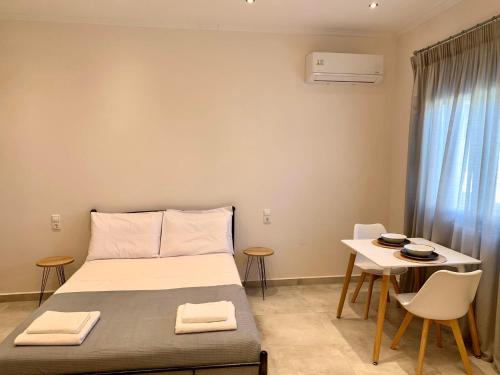 sypialnia z łóżkiem, stołem i krzesłami w obiekcie Lýria Boutique Apartments w mieście Ligia