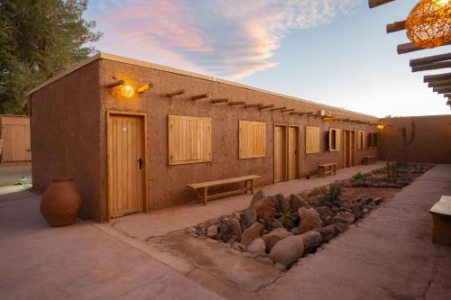 ein Gebäude mit einer Bank und Steinen davor in der Unterkunft Hotel Don Raul in San Pedro de Atacama