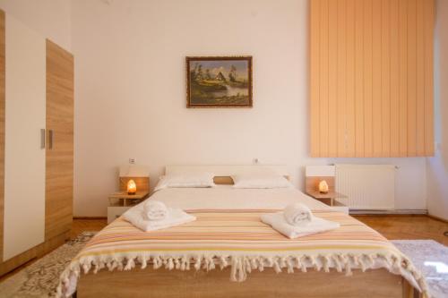 a bedroom with a large bed with towels on it at Barok Apartments in Braşov