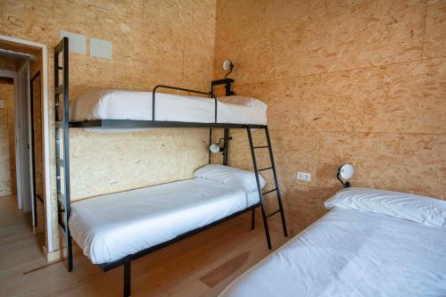 Ce lit se trouve dans un dortoir doté de 2 lits superposés et d'un mur. dans l'établissement Paorra Baserria, à Aia