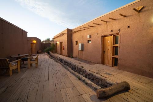 an outdoor patio with a table and a building at Hotel Don Raul in San Pedro de Atacama