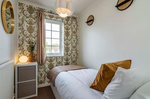Schlafzimmer mit einem Bett und einem Fenster in der Unterkunft Cosy Home - Contractors Welcome - Garden & Free Parking in Derby