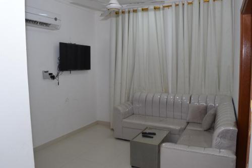 a living room with a couch and a flat screen tv at RED-7 - Alwadi Salalah in Salalah