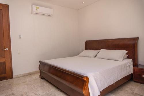 a bedroom with a bed with a wooden headboard at One Bedroom Apartment In Old City Of Cartagena in Cartagena de Indias