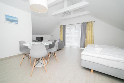 Schlafzimmer mit einem Bett, einem Tisch und Stühlen in der Unterkunft VacationClub - Stubai Apartament 38 in Heudorf